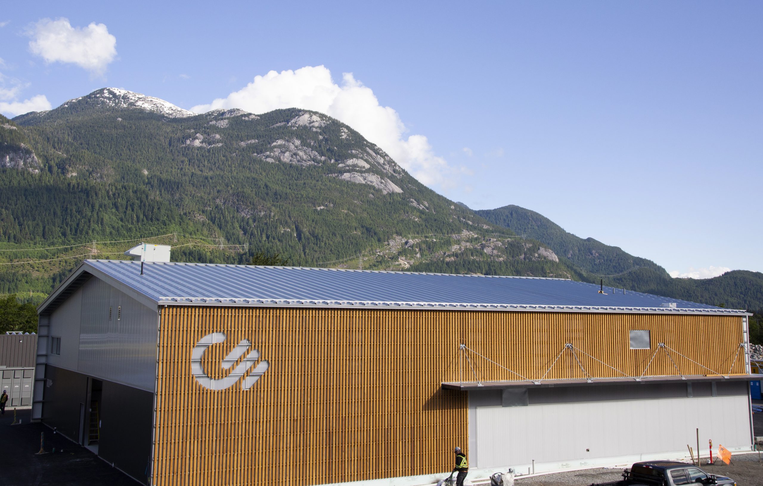An image of wood paneling on the Carbon Engineering office building exterior, with a mountain and blue sky in the background.